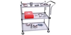 3D rendering of wheeled medical trolley with first aid kit, scissors, scalpel, stethoscope and other medical supplies against a white background.
