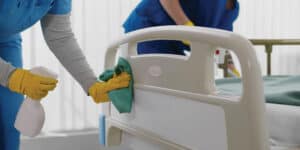 Staffs from professional cleaning service are sanitizing hospital beds and medical equipment.